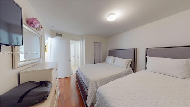bedroom featuring wood finished floors and visible vents