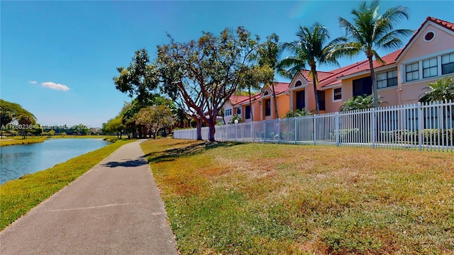exterior space featuring a water view, a yard, and fence