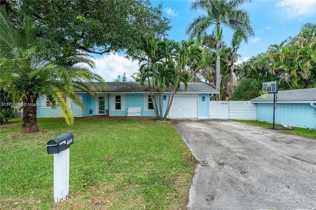 ranch-style house with a garage, driveway, a front yard, and fence