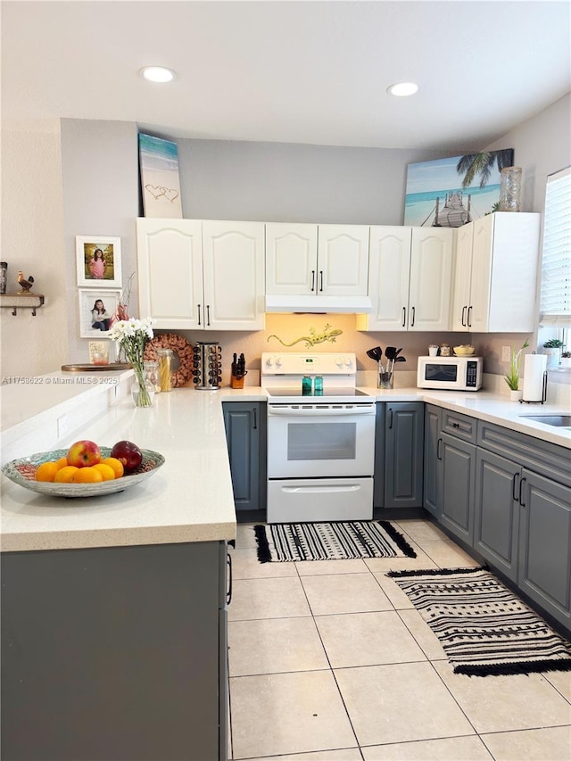 kitchen featuring gray cabinets, white cabinetry, white appliances, light countertops, and light tile patterned floors