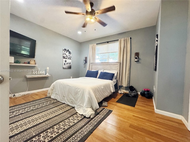 bedroom featuring ceiling fan, baseboards, and wood finished floors