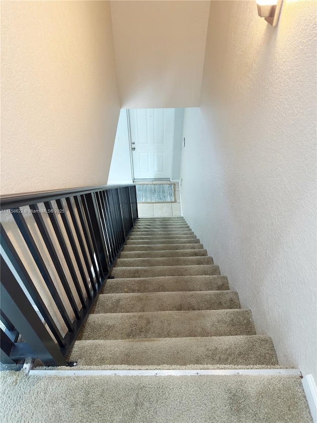 staircase featuring a textured wall