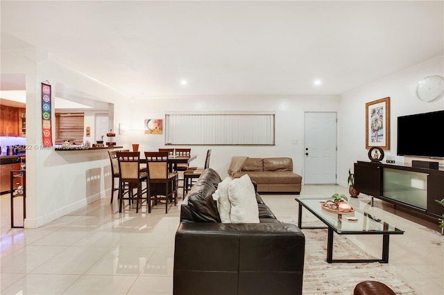 living room featuring light tile patterned floors, baseboards, ornamental molding, and recessed lighting