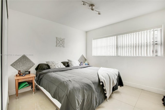 bedroom with baseboards and light tile patterned flooring