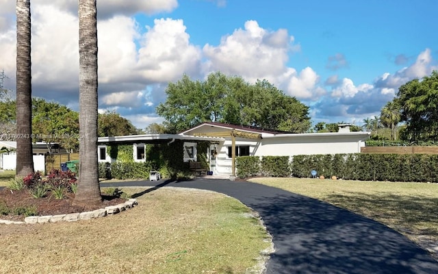 view of front facade featuring aphalt driveway and a front yard