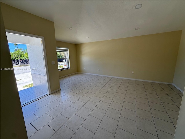 empty room with recessed lighting, baseboards, and light tile patterned floors