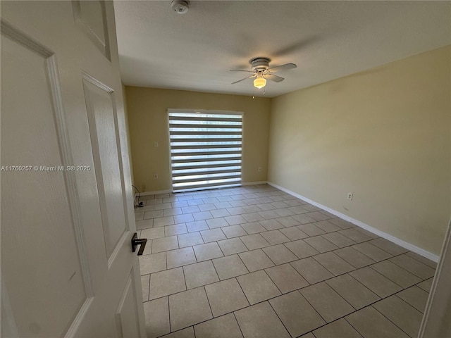unfurnished room featuring a ceiling fan, baseboards, and tile patterned flooring