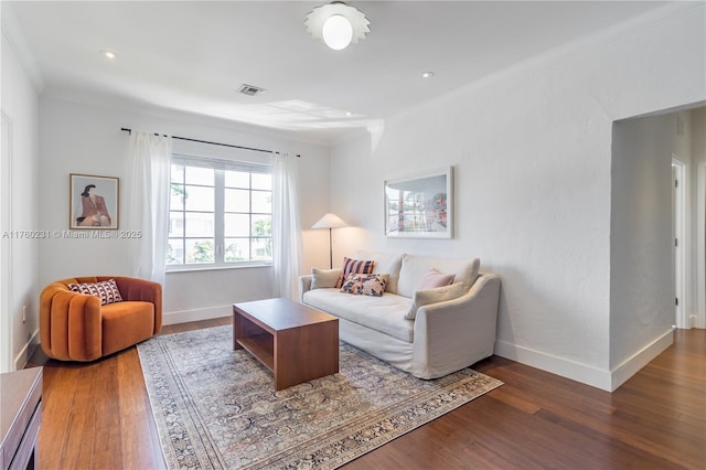 living area featuring ornamental molding, wood finished floors, visible vents, and baseboards