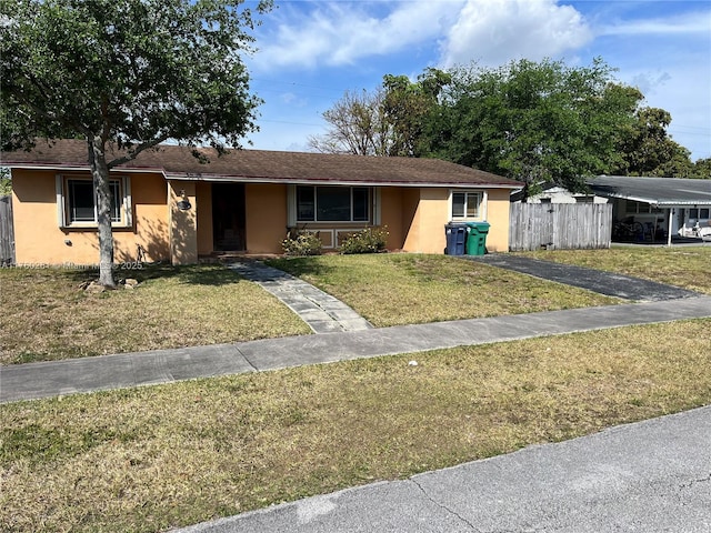 ranch-style home with stucco siding, a front yard, and fence