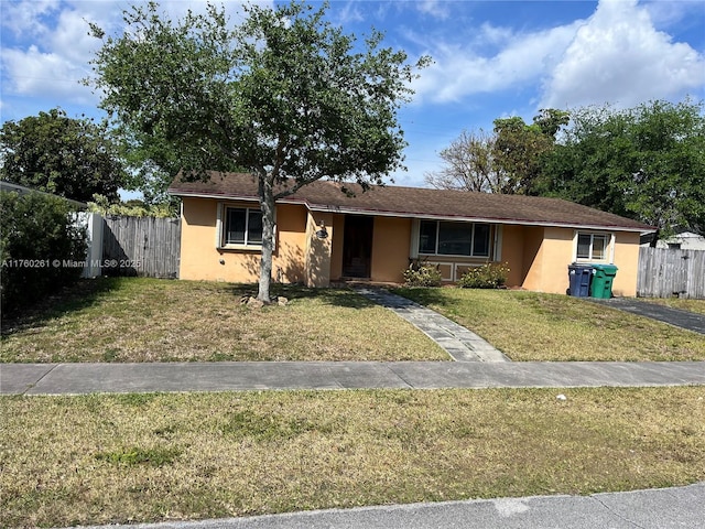 single story home featuring stucco siding, a front yard, and fence