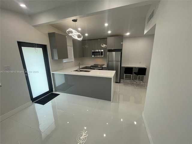 kitchen with light countertops, gray cabinets, appliances with stainless steel finishes, modern cabinets, and a sink