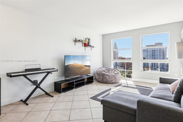 living room featuring light tile patterned floors, baseboards, and a healthy amount of sunlight