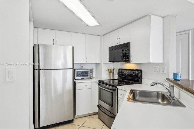 kitchen featuring a toaster, light tile patterned floors, white cabinets, stainless steel appliances, and a sink