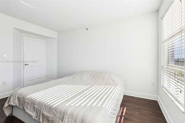 bedroom featuring dark wood finished floors and baseboards