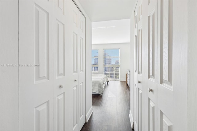 hallway featuring baseboards and dark wood-style floors