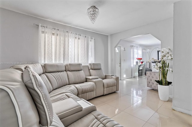 living room with light tile patterned floors and arched walkways