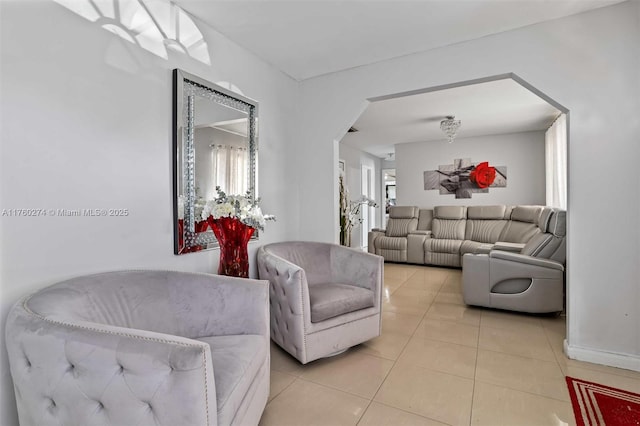 living area featuring light tile patterned floors and arched walkways