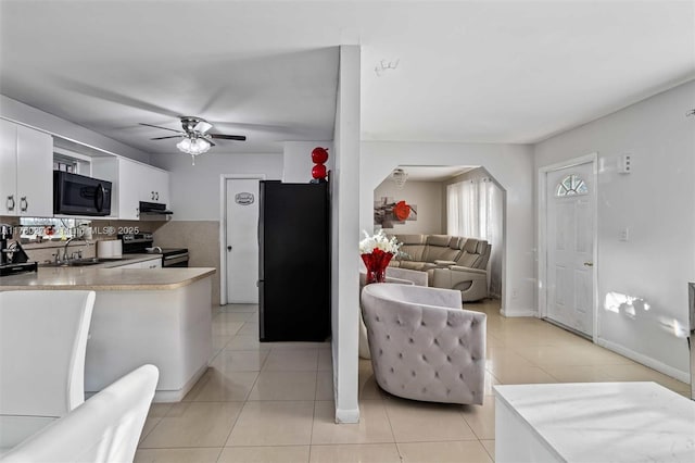 kitchen featuring arched walkways, appliances with stainless steel finishes, light countertops, and a sink