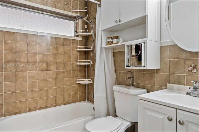 bathroom featuring tasteful backsplash, tile walls, toilet, shower / bath combination with curtain, and vanity