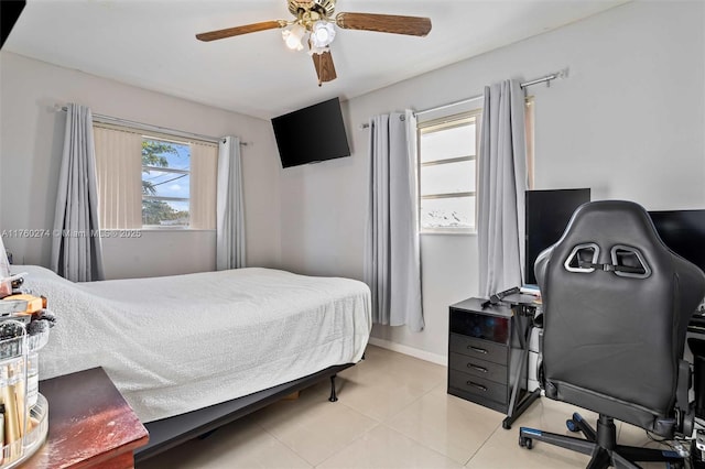 bedroom with a ceiling fan, multiple windows, light tile patterned flooring, and baseboards