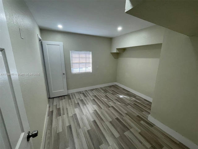 interior space featuring recessed lighting, baseboards, and wood finished floors