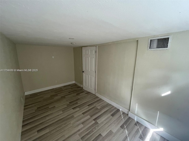 4896 SW 28th Ter, Dania Beach, FL 33312 - finished basement featuring visible vents, baseboards, a textured ceiling, and wood finished floors