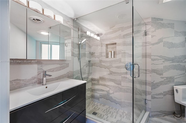 full bathroom featuring visible vents, vanity, a shower stall, and tile walls