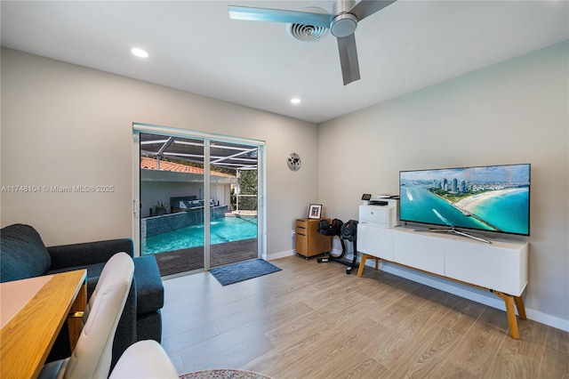 living room with a ceiling fan, baseboards, recessed lighting, and light wood-style flooring