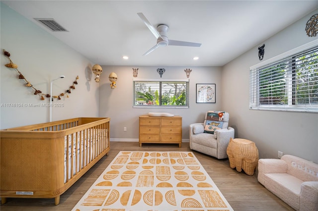 bedroom with visible vents, recessed lighting, wood finished floors, and multiple windows