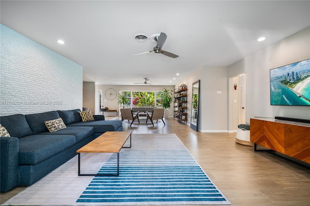 living room featuring a ceiling fan, wood finished floors, visible vents, baseboards, and recessed lighting