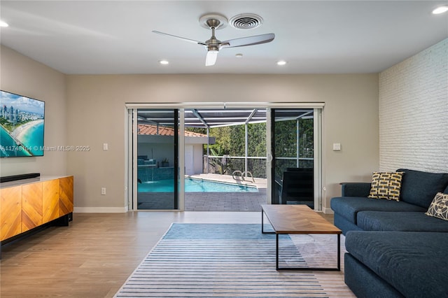 living room featuring a sunroom, a ceiling fan, recessed lighting, wood finished floors, and visible vents