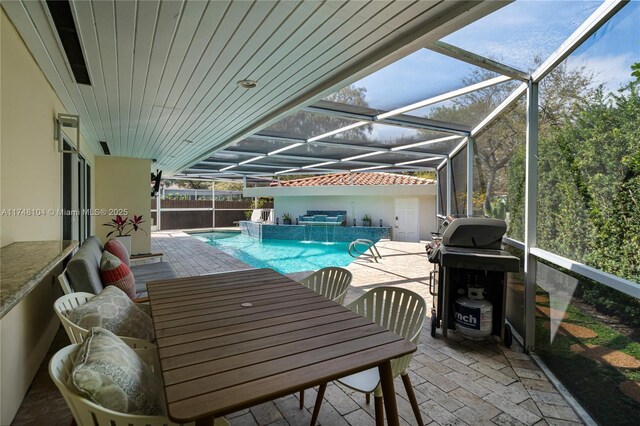 view of swimming pool with grilling area, a patio area, glass enclosure, a fenced in pool, and outdoor dining space