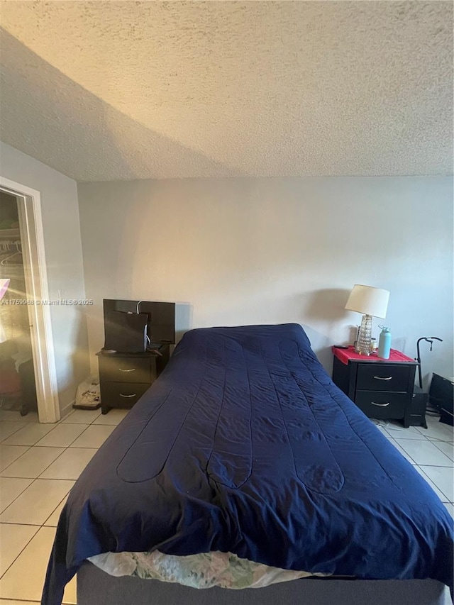 bedroom with light tile patterned floors and a textured ceiling