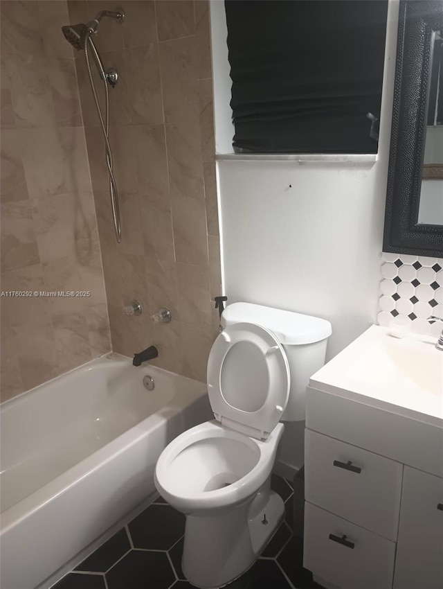 bathroom with tile patterned floors, vanity, toilet, and  shower combination