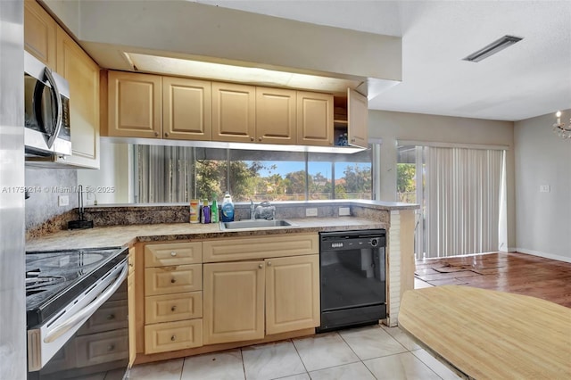 kitchen featuring visible vents, stainless steel microwave, black dishwasher, electric range, and a sink