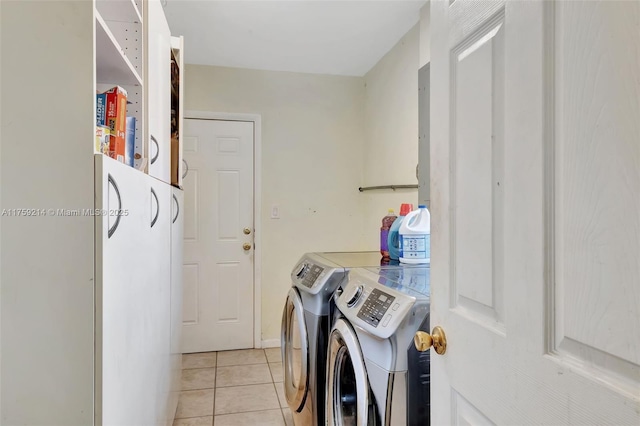 clothes washing area with laundry area, light tile patterned floors, and washing machine and clothes dryer