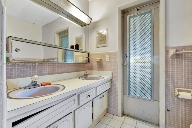 bathroom featuring tile patterned flooring, tile walls, double vanity, and a sink