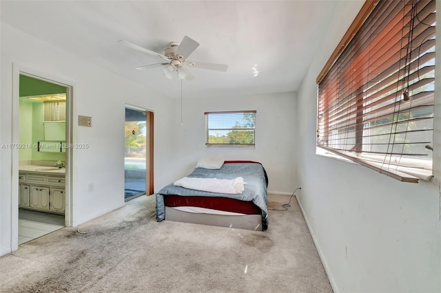 carpeted bedroom featuring access to exterior, connected bathroom, baseboards, ceiling fan, and a sink