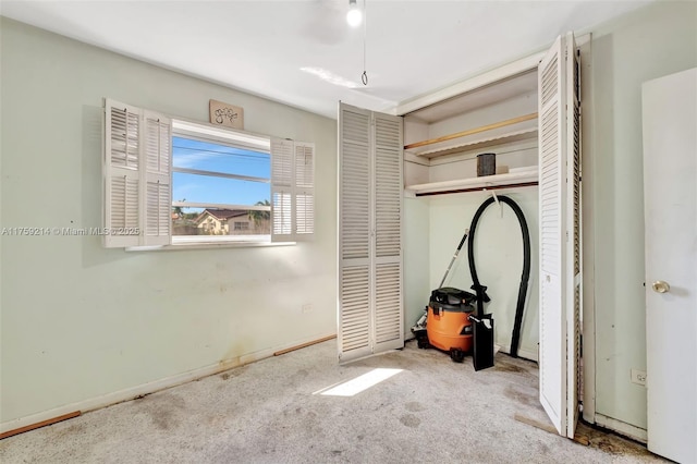 unfurnished bedroom featuring a closet, carpet floors, and baseboards