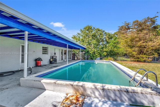 outdoor pool with a patio and fence private yard