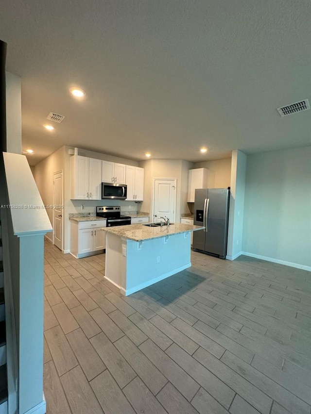 kitchen featuring visible vents, white cabinets, appliances with stainless steel finishes, and a sink