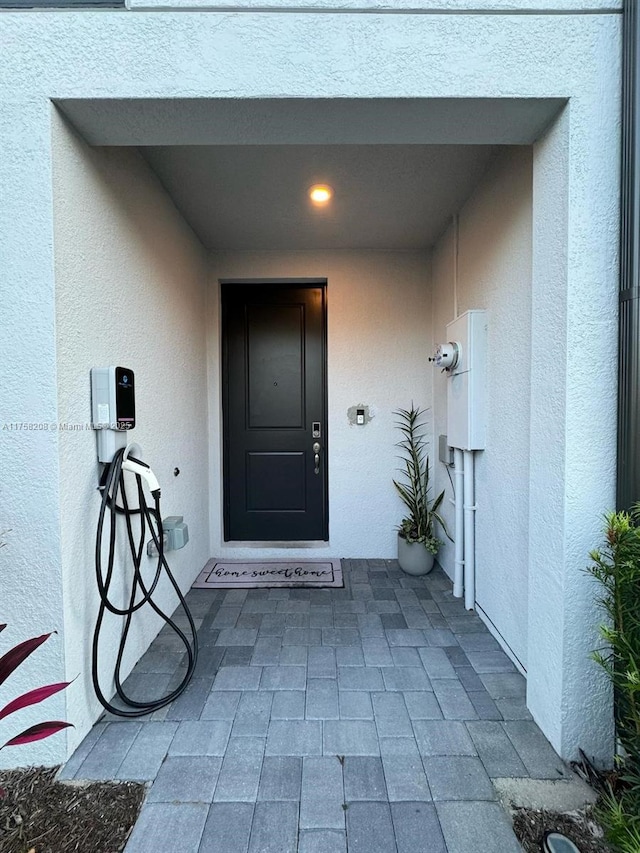 entrance to property featuring stucco siding