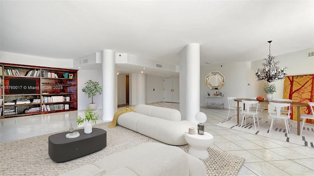 living area featuring light tile patterned flooring, visible vents, and an inviting chandelier