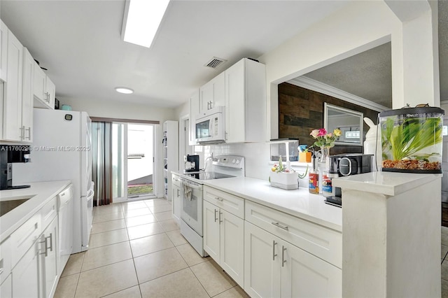 kitchen featuring visible vents, white appliances, white cabinets, light tile patterned floors, and decorative backsplash