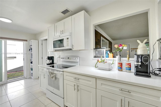 kitchen featuring tasteful backsplash, visible vents, light tile patterned flooring, white appliances, and white cabinetry