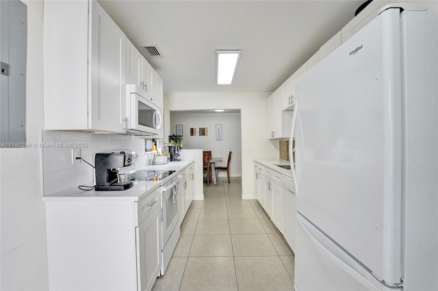 kitchen with white appliances, light tile patterned floors, visible vents, light countertops, and tasteful backsplash