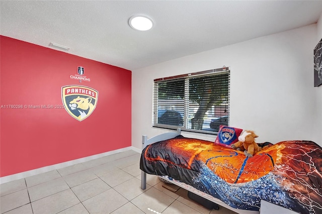 tiled bedroom featuring visible vents, baseboards, and a textured ceiling