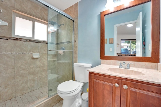 bathroom featuring vanity, toilet, a shower stall, and crown molding