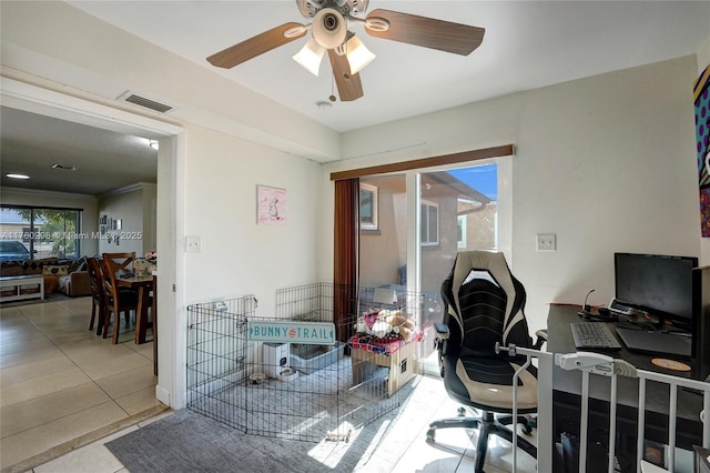 tiled office space featuring visible vents and ceiling fan