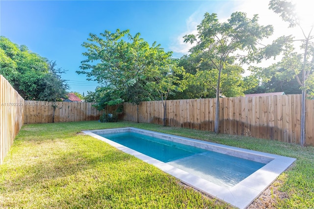 view of pool with a lawn and a fenced backyard